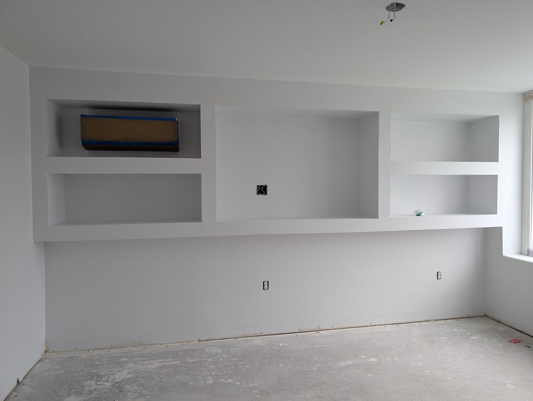 Finished white built-in shelving and a wall unit, painted and complete.