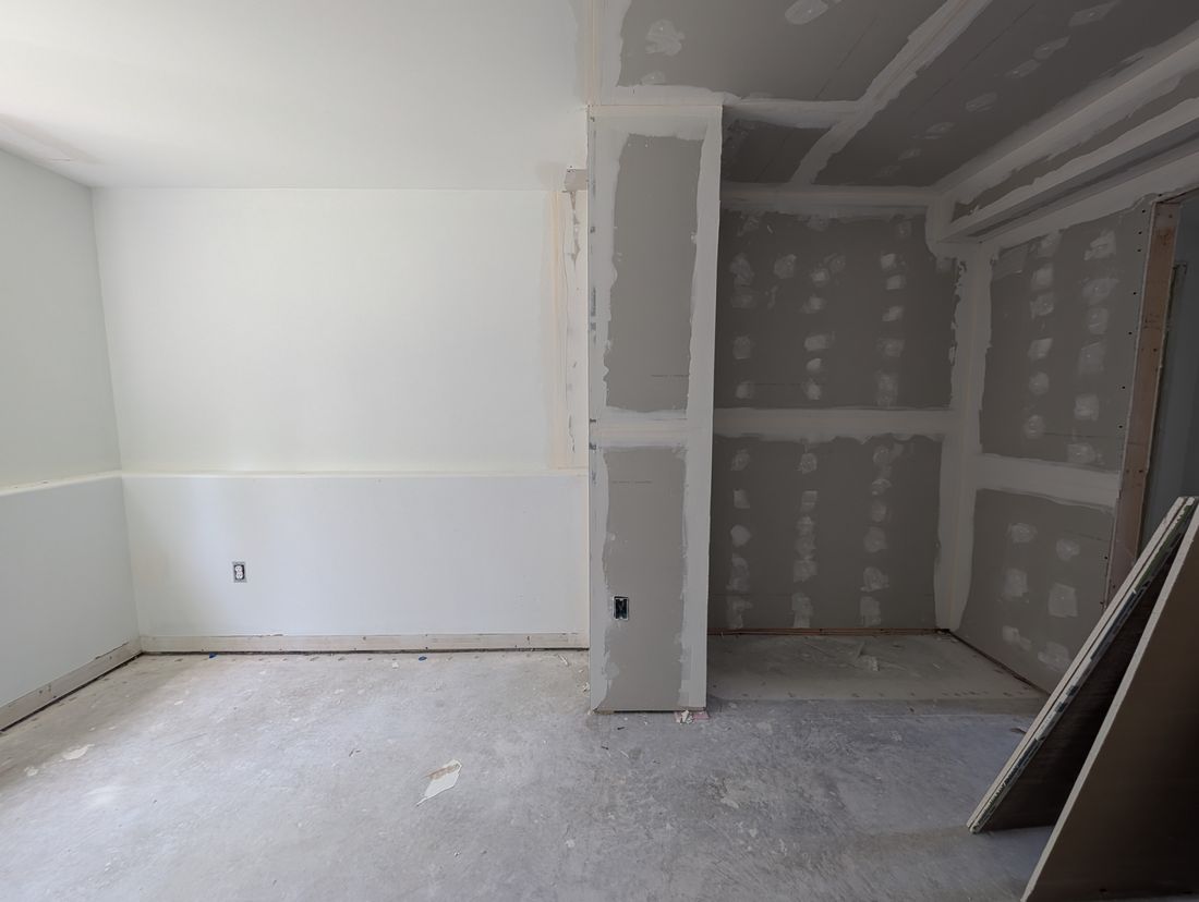 A bedroom with drywall hung and the seams taped and coated.